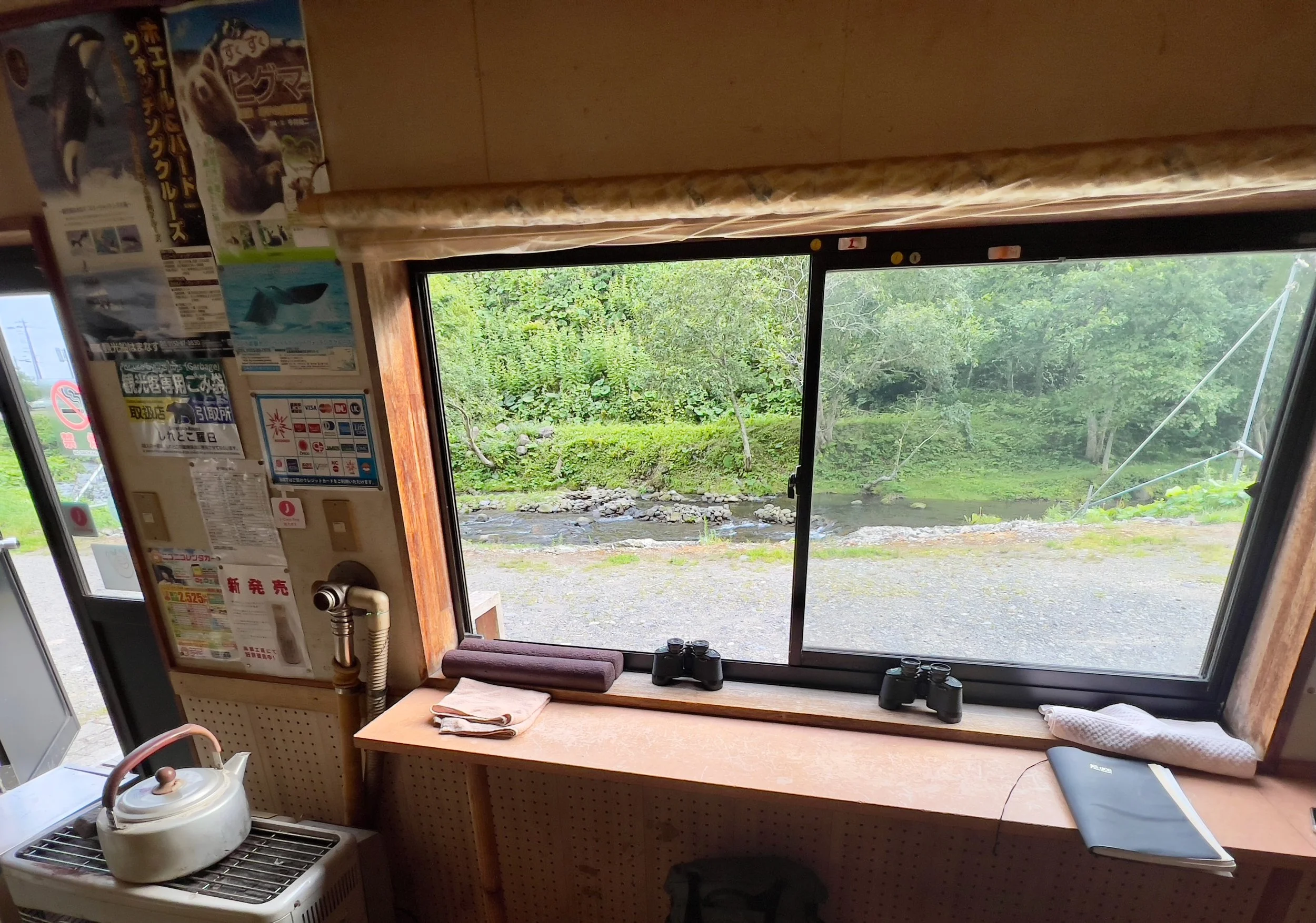 Interior of an observation hide in Shiretoko with binoculars and a view of a stream