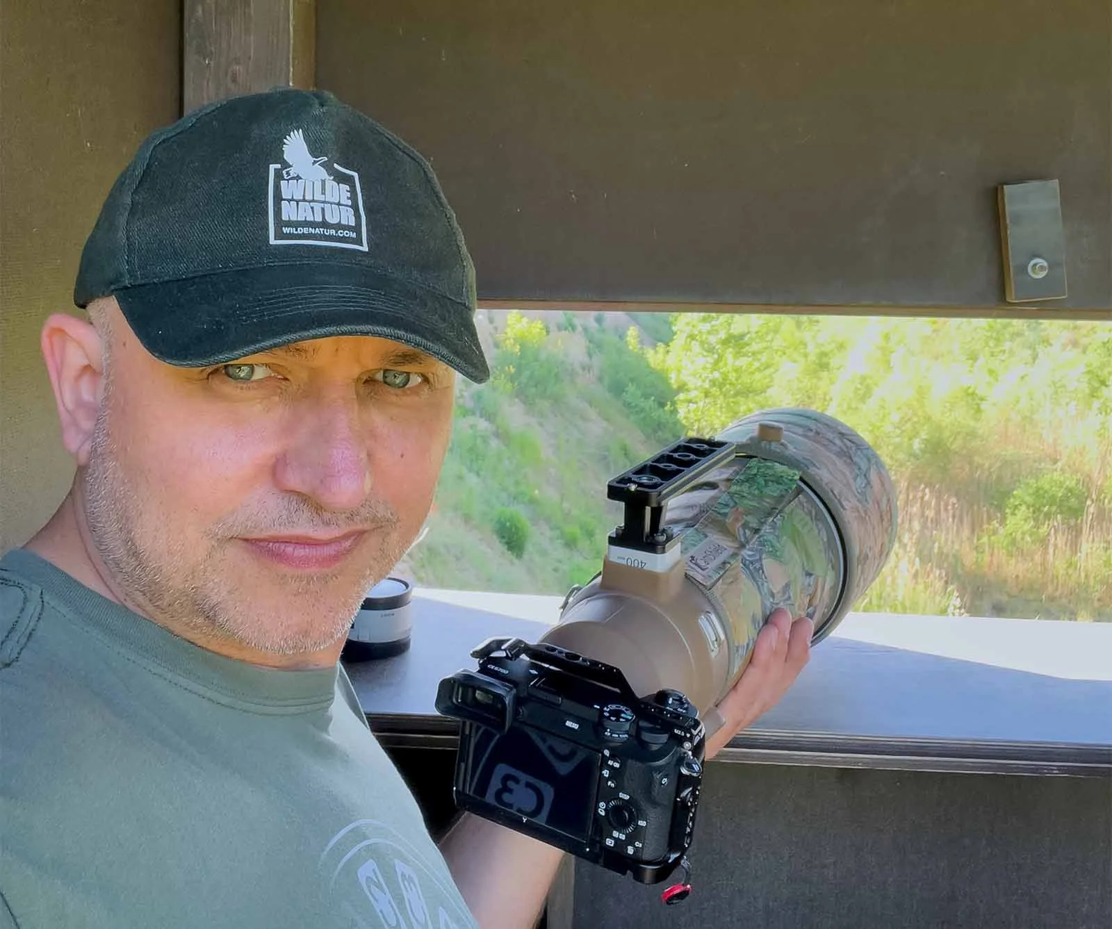 A man from WildeNatur sitting with the Sony a6700, 1.4x TC, and Sony 400 mm f2.8 in the bee-eater observation hut
