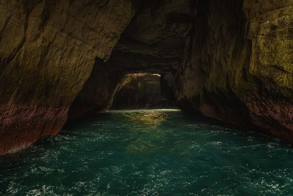 Emerald water in the rock passages of Tensodo sea cave with daylight entering in the background, Dogashima, Izu, Japan.