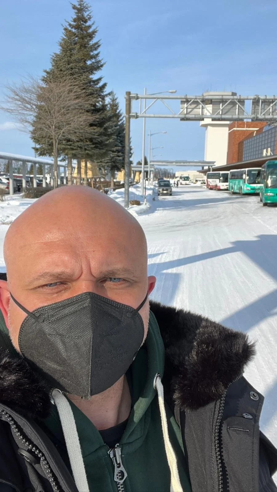 Markus masqué devant l’aéroport enneigé de Kushiro, au Japon.