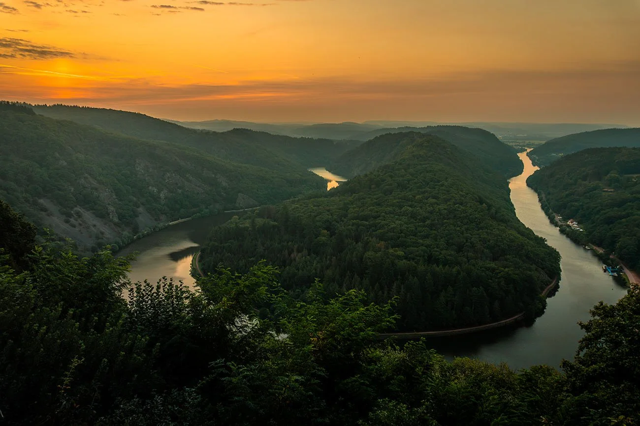 Saar Loop near Mettlach-Orscholz glowing orange at sunset, aerial view over the river bend.